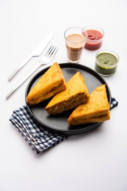 Sandviç ekmeği Pakora ya da Pakoda üçgeniyle servis edilen domates ketçapı, yeşil turşu, popüler Hint çay saati atıştırmalığı.