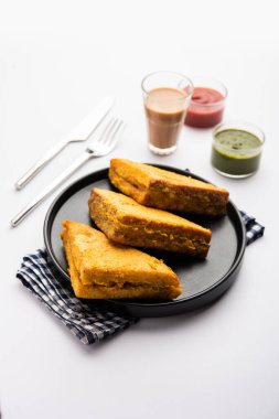 Sandviç ekmeği Pakora ya da Pakoda üçgeniyle servis edilen domates ketçapı, yeşil turşu, popüler Hint çay saati atıştırmalığı.