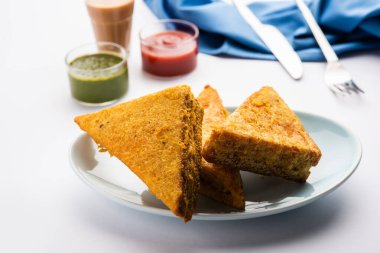 Sandviç ekmeği Pakora ya da Pakoda üçgeniyle servis edilen domates ketçapı, yeşil turşu, popüler Hint çay saati atıştırmalığı.