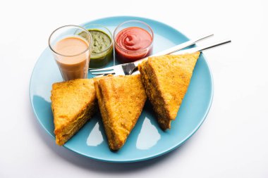 Sandviç ekmeği Pakora ya da Pakoda üçgeniyle servis edilen domates ketçapı, yeşil turşu, popüler Hint çay saati atıştırmalığı.