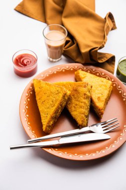 Sandviç ekmeği Pakora ya da Pakoda üçgeniyle servis edilen domates ketçapı, yeşil turşu, popüler Hint çay saati atıştırmalığı.