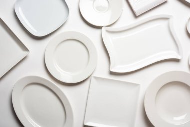 beyaz arkaplanda izole edilmiş farklı şekilli beyaz plakalar, üst görünüm