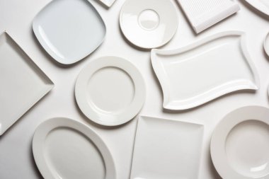 beyaz arkaplanda izole edilmiş farklı şekilli beyaz plakalar, üst görünüm