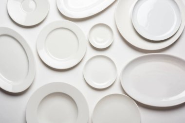 beyaz arkaplanda izole edilmiş farklı şekilli beyaz plakalar, üst görünüm