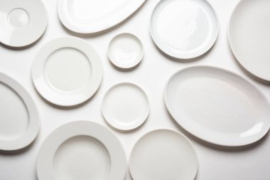 beyaz arkaplanda izole edilmiş farklı şekilli beyaz plakalar, üst görünüm