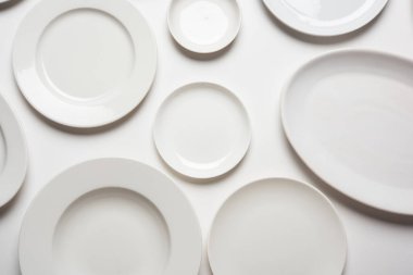 beyaz arkaplanda izole edilmiş farklı şekilli beyaz plakalar, üst görünüm