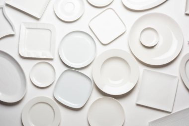beyaz arkaplanda izole edilmiş farklı şekilli beyaz plakalar, üst görünüm