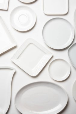 beyaz arkaplanda izole edilmiş farklı şekilli beyaz plakalar, üst görünüm