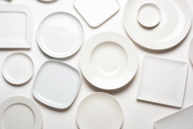 beyaz arkaplanda izole edilmiş farklı şekilli beyaz plakalar, üst görünüm