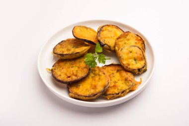 Lezzetli Brinjal Pakora veya çıtır patlıcanlı börek, Hint çay saati aperatifi yeşil baharatla servis edilir.