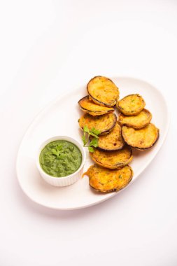 Lezzetli Brinjal Pakora veya çıtır patlıcanlı börek, Hint çay saati aperatifi yeşil baharatla servis edilir.