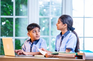 Sınıf Üniformalarını Giyerken Dizüstü Bilgisayarda Birlikte Çalışan Hintli Okul Çocukları, Grup Öğrenimi, Bilgi Paylaşımı, Eğitim sırasında Akademik Görevler Kullanımı Teknolojisi İşbirliği