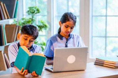 Sınıf Üniformalarını Giyerken Dizüstü Bilgisayarda Birlikte Çalışan Hintli Okul Çocukları, Grup Öğrenimi, Bilgi Paylaşımı, Eğitim sırasında Akademik Görevler Kullanımı Teknolojisi İşbirliği