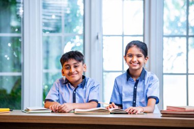 Okul üniformalarını giyerken birlikte ders çalışan Hintli Okul Çocukları, Öğrenim, Okuma, Akademik Oturumda Bilgi Paylaşım, Eğitim ve Takım Çalışmaları konularına odaklandı.