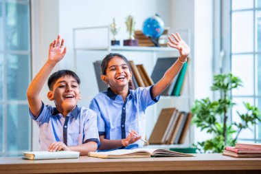 Hintli Okul Çocukları, Okul üniformalarını giyerken, Öğrenim Sürecine katılırken, Öğrenci Etkileşimine Odaklanılan Öğrenci Etkileşimine Odaklanırken, Bir Sınıfta Soruya Cevap Vermek İçin El Kaldırıyor