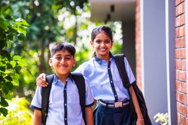 Hintli Okul Çocukları Kameraya Bakıyor Okul üniformalarıyla Dışarıda Duruyor, Doğal Işıkta Parlak İfadelerle Mutlu Bir Poz Veriyor, Eğitimde Neşeli Anları Yakalıyor