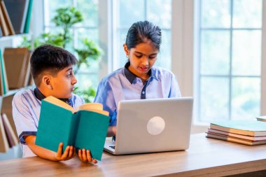 Sınıf Üniformalarını Giyerken Dizüstü Bilgisayarda Birlikte Çalışan Hintli Okul Çocukları, Grup Öğrenimi, Bilgi Paylaşımı, Eğitim sırasında Akademik Görevler Kullanımı Teknolojisi İşbirliği