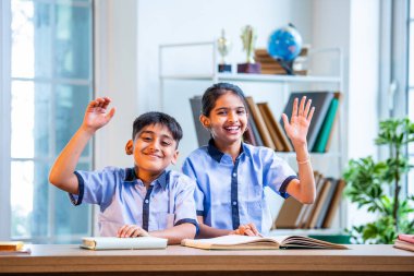 Hintli Okul Çocukları, Okul üniformalarını giyerken, Öğrenim Sürecine katılırken, Öğrenci Etkileşimine Odaklanılan Öğrenci Etkileşimine Odaklanırken, Bir Sınıfta Soruya Cevap Vermek İçin El Kaldırıyor