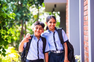 Hintli Okul Çocukları Kameraya Bakıyor Okul üniformalarıyla Dışarıda Duruyor, Doğal Işıkta Parlak İfadelerle Mutlu Bir Poz Veriyor, Eğitimde Neşeli Anları Yakalıyor