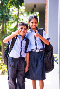 Hintli Okul Çocukları Kameraya Bakıyor Okul üniformalarıyla Dışarıda Duruyor, Doğal Işıkta Parlak İfadelerle Mutlu Bir Poz Veriyor, Eğitimde Neşeli Anları Yakalıyor