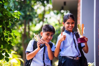 Hintli Okul Çocukları, Açık Hava Kameralarına Bakıyor Okul üniformaları Giyiyor, Başarı ve Başarı Kutlaması Mutlulukla poz verirken Güneşli bir günde gururla