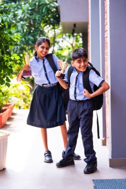 Hintli Okul Çocukları, Açık Hava Kameralarına Bakıyor Okul üniformaları Giyiyor, Başarı ve Başarı Kutlaması Mutlulukla poz verirken Güneşli bir günde gururla