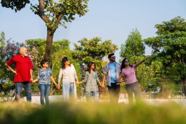 Hintli aile, dışarıda dolaşırken neşe dolu anların tadını çıkarıyor, hafta sonu rahatça dışarı çıkarken kahkaha, neşe ve bağlantı paylaşıyor, sıcak duygular yakalıyor.