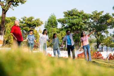 Hintli aile, dışarıda dolaşırken neşe dolu anların tadını çıkarıyor, hafta sonu rahatça dışarı çıkarken kahkaha, neşe ve bağlantı paylaşıyor, sıcak duygular yakalıyor.