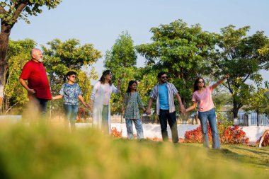 Hintli aile, dışarıda dolaşırken neşe dolu anların tadını çıkarıyor, hafta sonu rahatça dışarı çıkarken kahkaha, neşe ve bağlantı paylaşıyor, sıcak duygular yakalıyor.