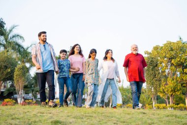 Hintli aile, yeşil ekinlerle birlikte çiftlikte geziniyor. Mutlu sohbetler ve muhabbetin tadını çıkarıyor. Büyükbabalar, ebeveynler ve çocuklar doğada barışçıl zaman geçiriyorlar.