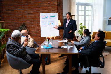 Hintli işadamları, Hindistan 'ın Asya iş dünyasının üst düzey yöneticileri olarak, şirket büyümesini ve finansal projeksiyon stratejisini modern ofiste incelerken, grafikte tartışıyorlar.