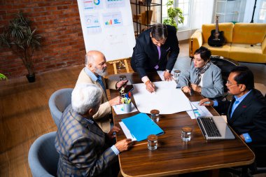 Hintli işadamları, Hindistan 'da rahat modern ofis masasında çalışırken, üst düzey Asyalı iş adamları ve üst düzey yönetim stratejisi olarak plan üzerinde tartışıyorlar.