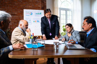 Hintli işadamları, Hindistan 'da rahat modern ofis masasında çalışırken, üst düzey Asyalı iş adamları ve üst düzey yönetim stratejisi olarak plan üzerinde tartışıyorlar.