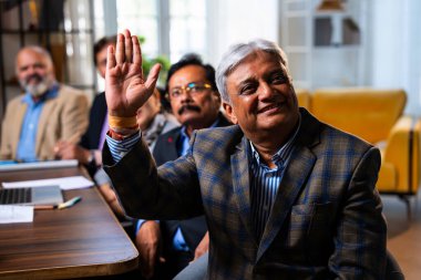 Hintli beş iş adamı sunum ve alkışları Hintli üst düzey Asyalı iş adamlarına yakın plan olarak görüyor ve modern ofis içinde masada otururken veya ayakta dururken başarılı brifing veriyorlar.