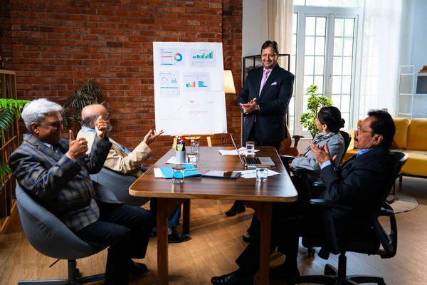 Hintli işadamları, Hindistan 'ın Asya iş dünyasının üst düzey yöneticileri olarak, şirket büyümesini ve finansal projeksiyon stratejisini modern ofiste incelerken, grafikte tartışıyorlar.