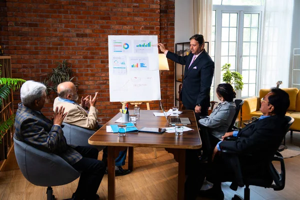 Hintli işadamları, Hindistan 'ın Asya iş dünyasının üst düzey yöneticileri olarak, şirket büyümesini ve finansal projeksiyon stratejisini modern ofiste incelerken, grafikte tartışıyorlar.