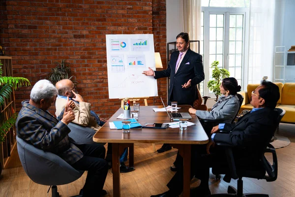 Hintli işadamları, Hindistan 'ın Asya iş dünyasının üst düzey yöneticileri olarak, şirket büyümesini ve finansal projeksiyon stratejisini modern ofiste incelerken, grafikte tartışıyorlar.