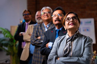 Hintli beş iş adamı sunum ve alkışları Hintli üst düzey Asyalı iş adamlarına yakın plan olarak görüyor ve modern ofis içinde masada otururken veya ayakta dururken başarılı brifing veriyorlar.