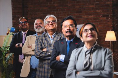 Hintli beş iş adamı sunum ve alkışları Hintli üst düzey Asyalı iş adamlarına yakın plan olarak görüyor ve modern ofis içinde masada otururken veya ayakta dururken başarılı brifing veriyorlar.