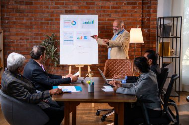 Hintli işadamları, Hindistan 'ın Asya iş dünyasının üst düzey yöneticileri olarak, şirket büyümesini ve finansal projeksiyon stratejisini modern ofiste incelerken, grafikte tartışıyorlar.