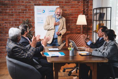 Hintli işadamları, Hindistan 'ın üst düzey Asyalı iş adamları olarak sunum yaparken el sıkışıyorlar. Yüksek yönetim, samimi modern ofis grafiği kullanarak başarılı büyüme projeksiyonunu kutluyor.