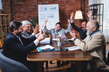 Hintli iş adamları, Hintli üst düzey Asyalı yöneticilerin modern ofis işyerindeki şirket toplantılarında elde ettikleri başarıları alkışlayarak ve beşlik çakarak kutluyorlar.