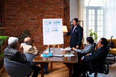 Hintli işadamları, Hindistan 'ın Asya iş dünyasının üst düzey yöneticileri olarak, şirket büyümesini ve finansal projeksiyon stratejisini modern ofiste incelerken, grafikte tartışıyorlar.