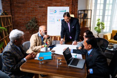 Hintli işadamları, Hindistan 'da rahat modern ofis masasında çalışırken, üst düzey Asyalı iş adamları ve üst düzey yönetim stratejisi olarak plan üzerinde tartışıyorlar.