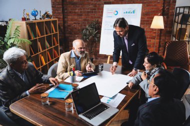 Hintli işadamları, Hindistan 'da rahat modern ofis masasında çalışırken, üst düzey Asyalı iş adamları ve üst düzey yönetim stratejisi olarak plan üzerinde tartışıyorlar.
