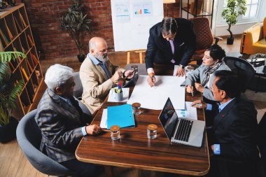 Hintli işadamları, Hindistan 'da rahat modern ofis masasında çalışırken, üst düzey Asyalı iş adamları ve üst düzey yönetim stratejisi olarak plan üzerinde tartışıyorlar.