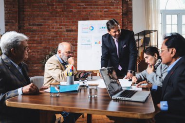 Hintli işadamları, Hindistan 'da rahat modern ofis masasında çalışırken, üst düzey Asyalı iş adamları ve üst düzey yönetim stratejisi olarak plan üzerinde tartışıyorlar.