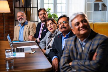 Hintli beş iş adamı sunum ve alkışları Hintli üst düzey Asyalı iş adamlarına yakın plan olarak görüyor ve modern ofis içinde masada otururken veya ayakta dururken başarılı brifing veriyorlar.