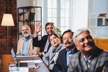 Hintli beş iş adamı sunum ve alkışları Hintli üst düzey Asyalı iş adamlarına yakın plan olarak görüyor ve modern ofis içinde masada otururken veya ayakta dururken başarılı brifing veriyorlar.