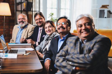 Hintli beş iş adamı sunum ve alkışları Hintli üst düzey Asyalı iş adamlarına yakın plan olarak görüyor ve modern ofis içinde masada otururken veya ayakta dururken başarılı brifing veriyorlar.